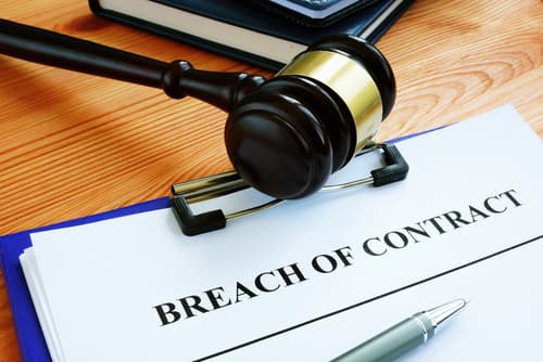 breach of contract paperwork on desk with gavel