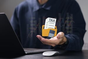 Person using computer to fill out personal income tax return to pay taxes online.