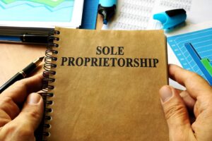 Hands holding book with title Sole proprietorship.